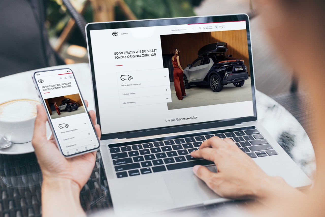 Ein Laptop und ein Smartphone auf einem Tisch, die den Toyota Online Shop geöffnet haben